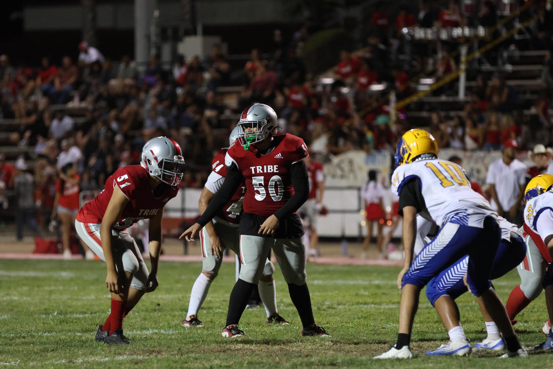 Varsity football players in action against Parlier 104