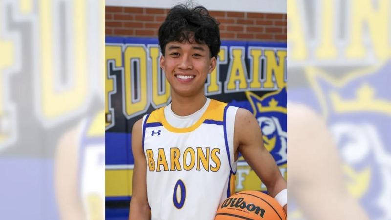photo of Kenneth Nguyen holding basketball in Fountain Valley High School gymnasium