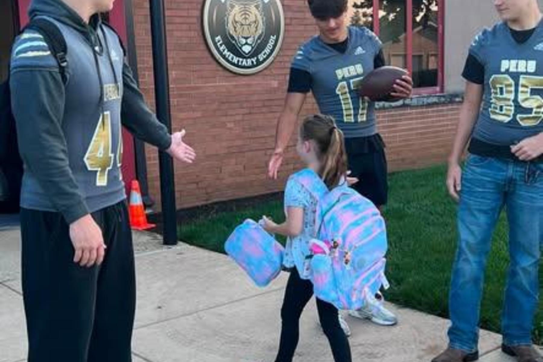 Football players greeting Elmwood students
