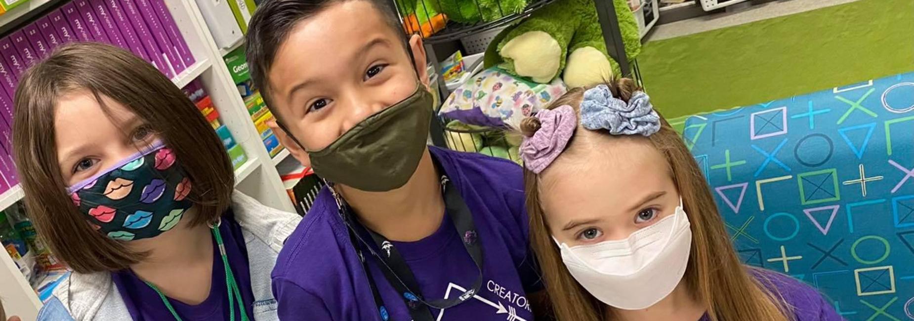 2 girls and a boy wearing matching purple shirts