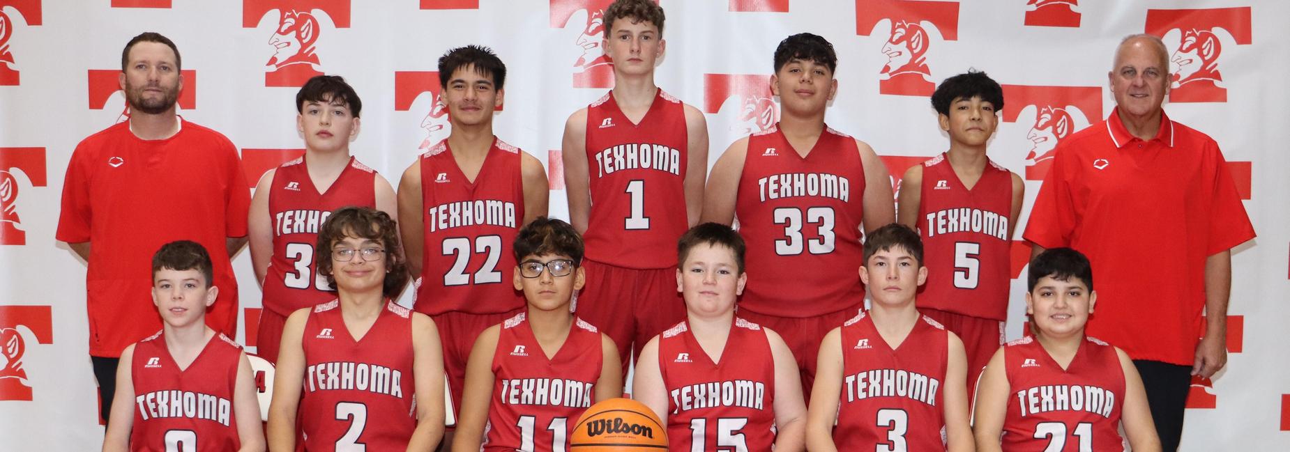 Youth basketball team in red jerseys, posing with a basketball.