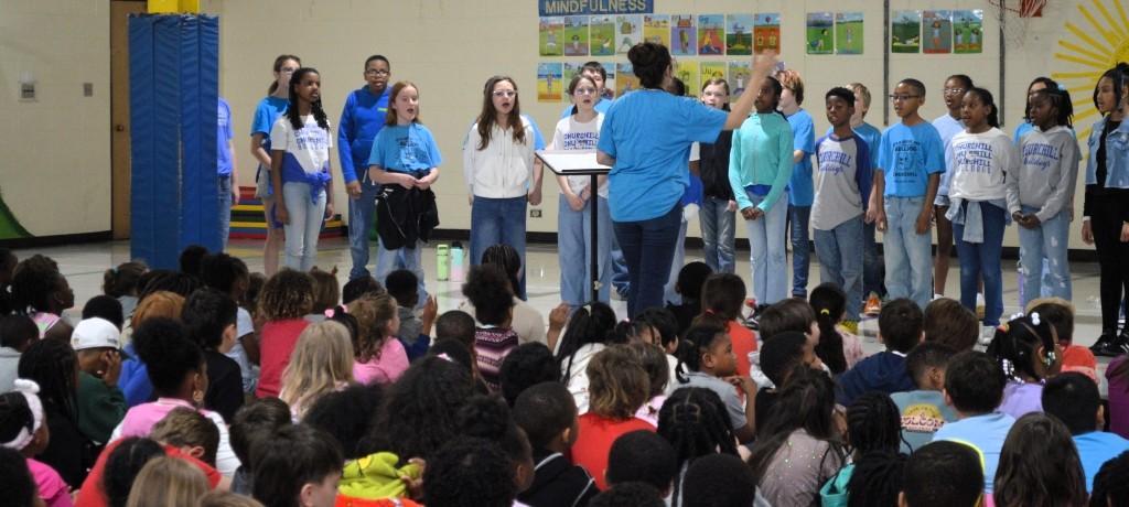 students in matching blue t-shirts singing
