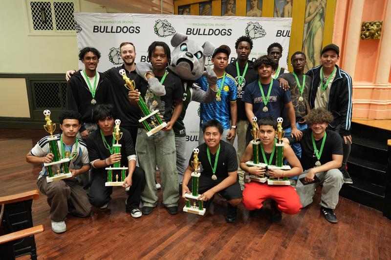 Group photo of athletes with awards and the Bulldog mascot at the banquet.