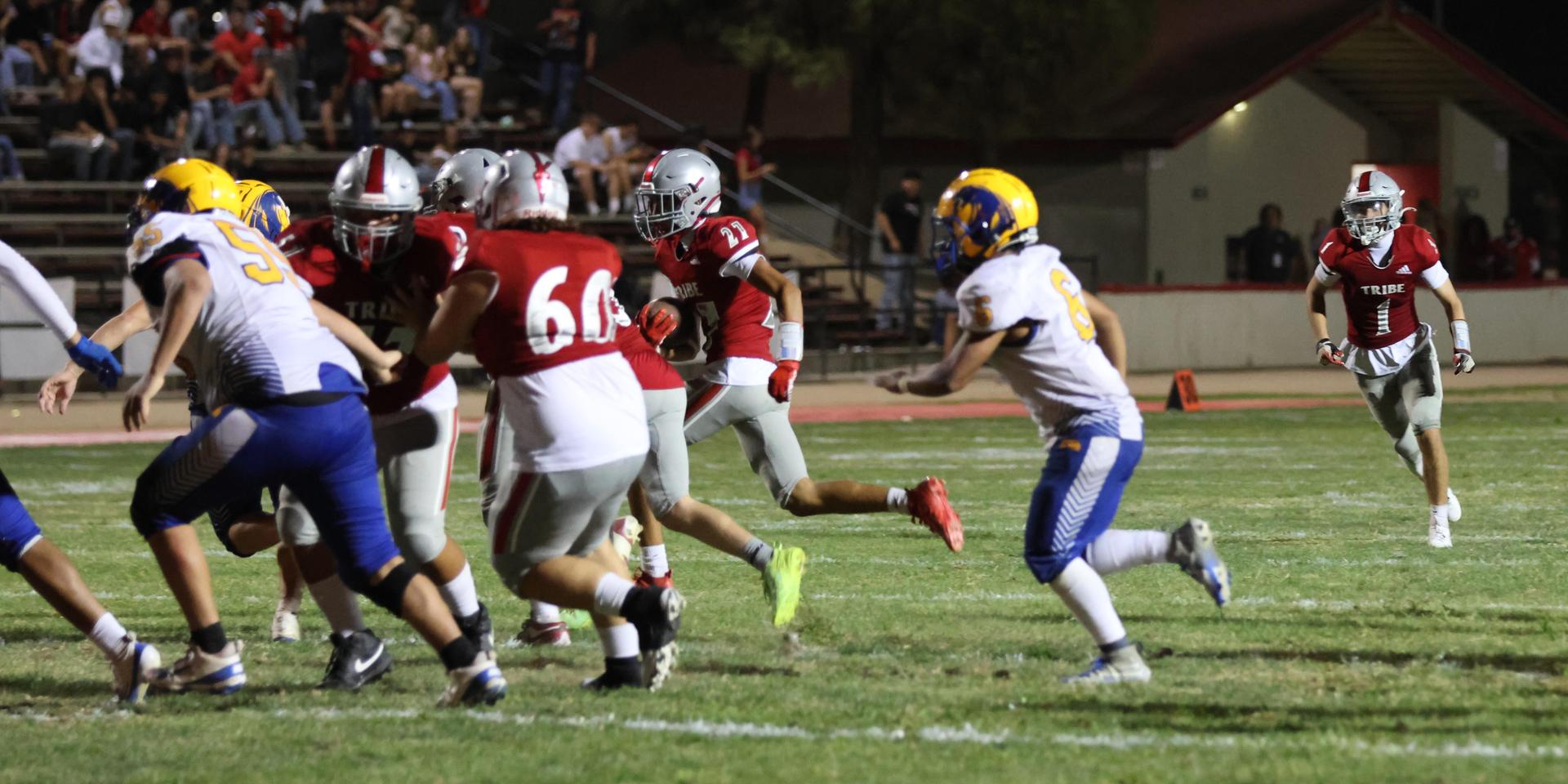 Varsity football players in action against Parlier 85