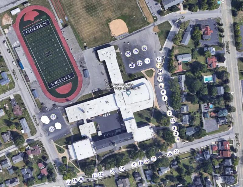 Aerial view of a school campus with adjacent sports fields and residential areas.