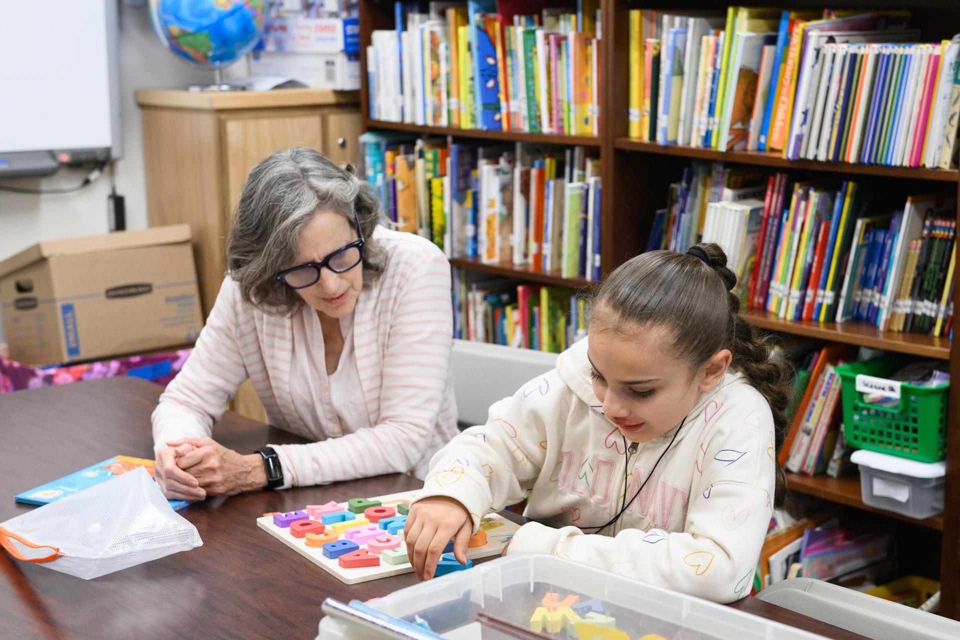 Teacher with student in library