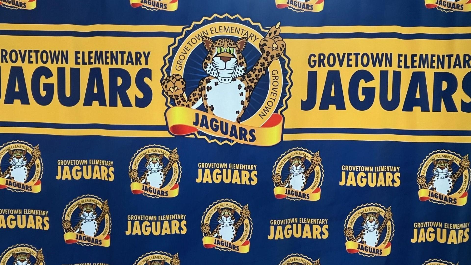 A blue and yellow banner featuring a jaguar mascot and 'GROVETOWN ELEMENTARY JAGUARS'.