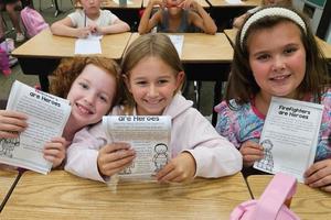 Iris Florio, Bri Keibler, and Samantha Younger hold their 9/11 workbooks
