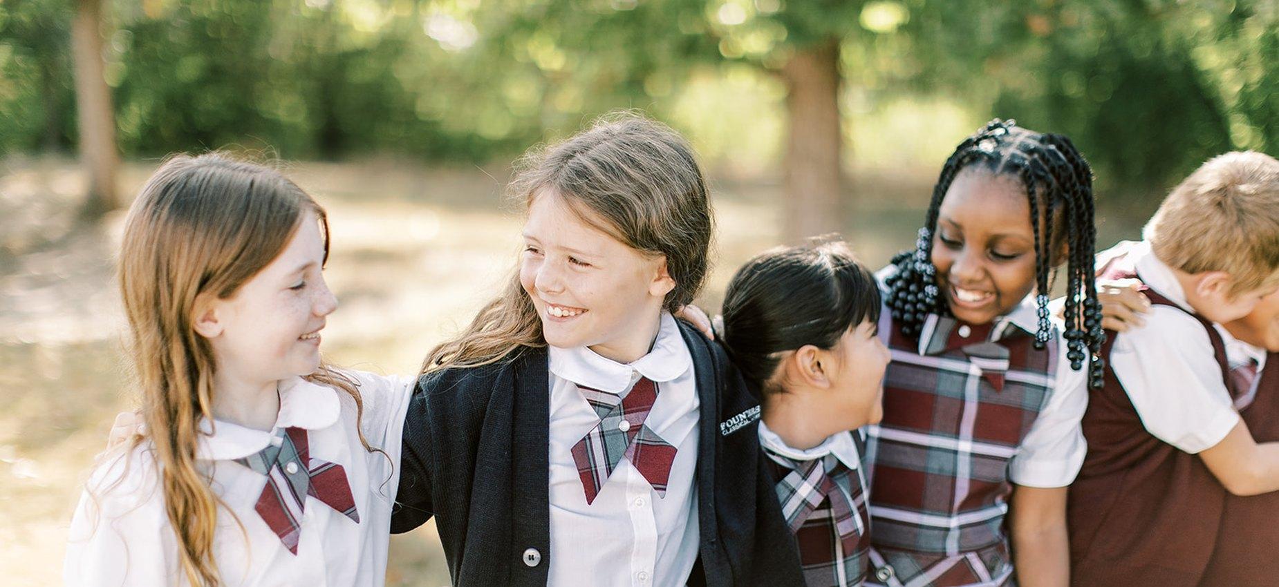 Founders Classical Academy of Fort Worth students laughing together under the trees
