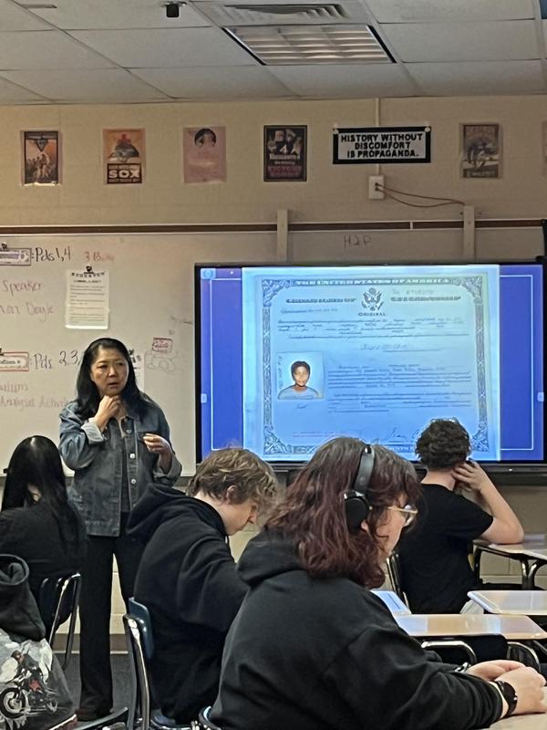 korean woman standing in front of her korean passport on projector