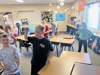 Kids engaged in an activity in a classroom dancing to 