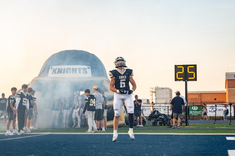 football player screaming and jumping in front of tunnel