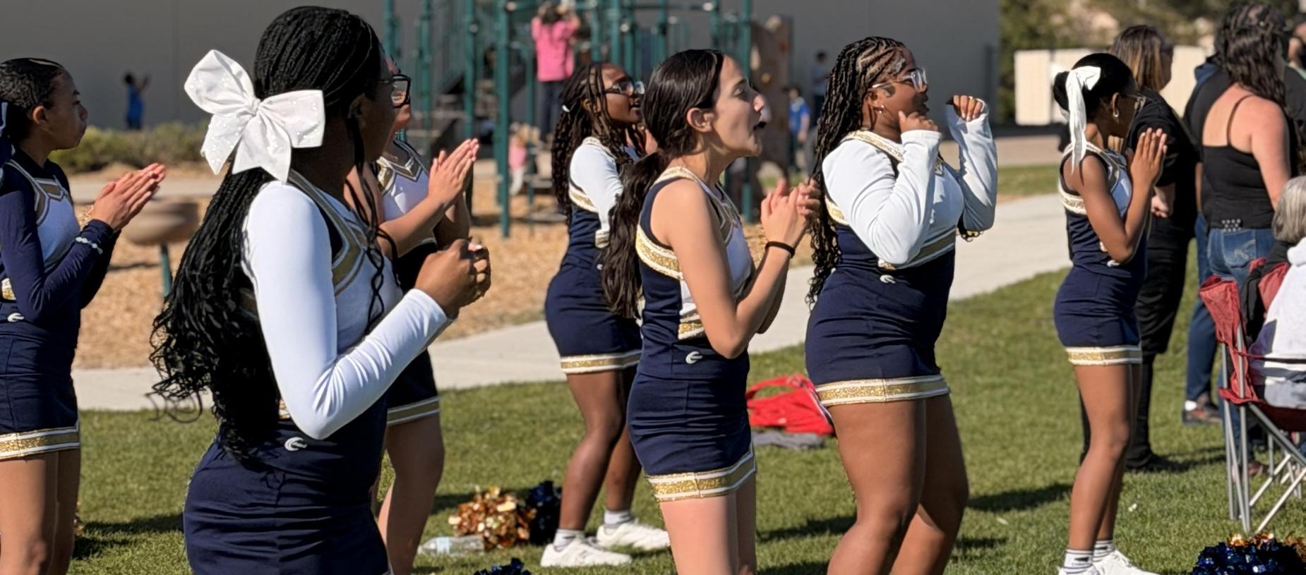 A group of cheerleaders performing a routine outdoors.