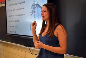 Student presenting in front of a screen with a detailed itinerary.