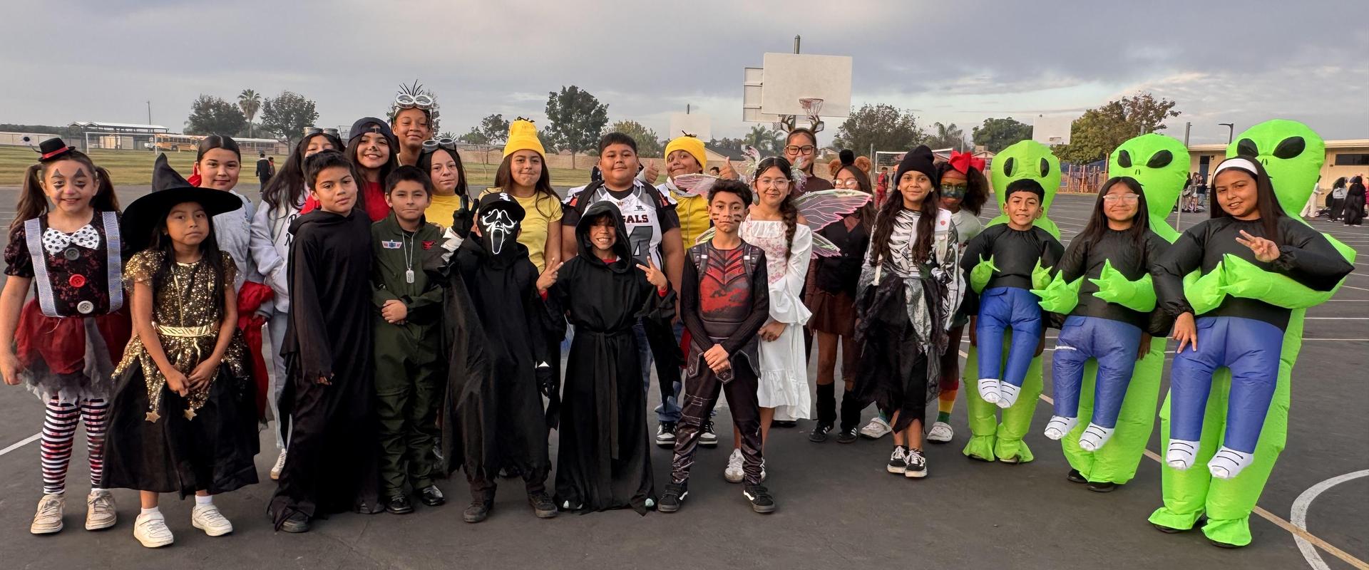Large group of children in various costumes, including aliens and witches.