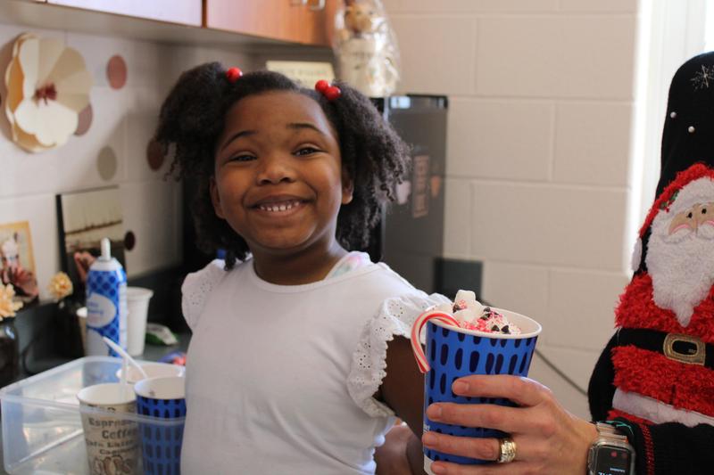 kindergartener with big smile with a hot chocolate cup