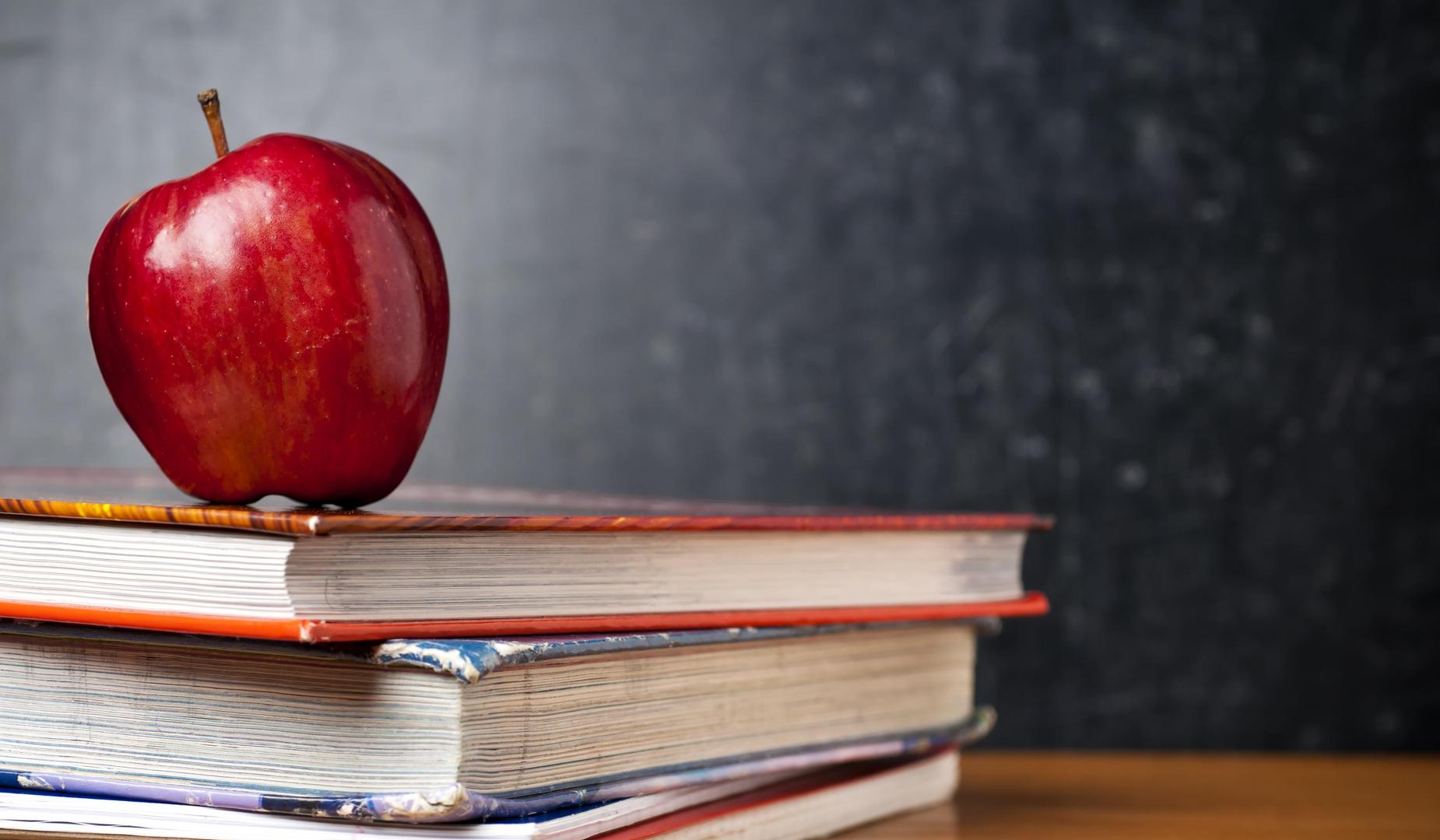 Stacked books with an apple on top