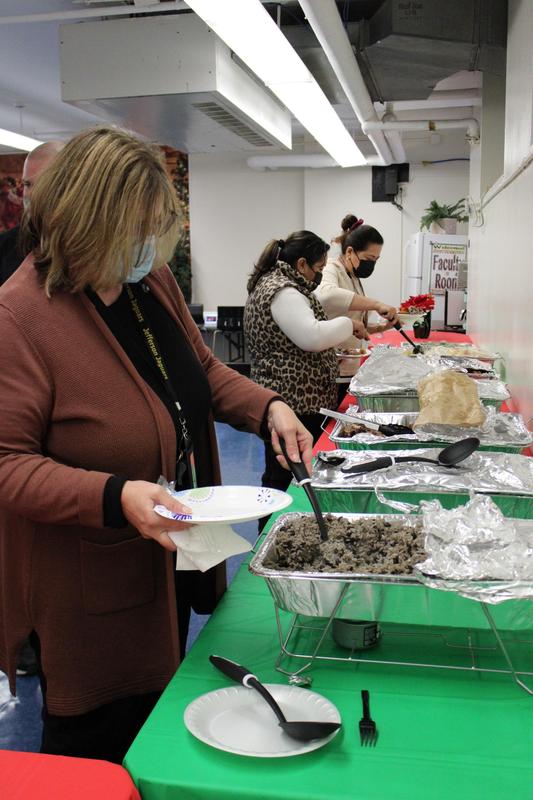 3 women serving themselves food from platters