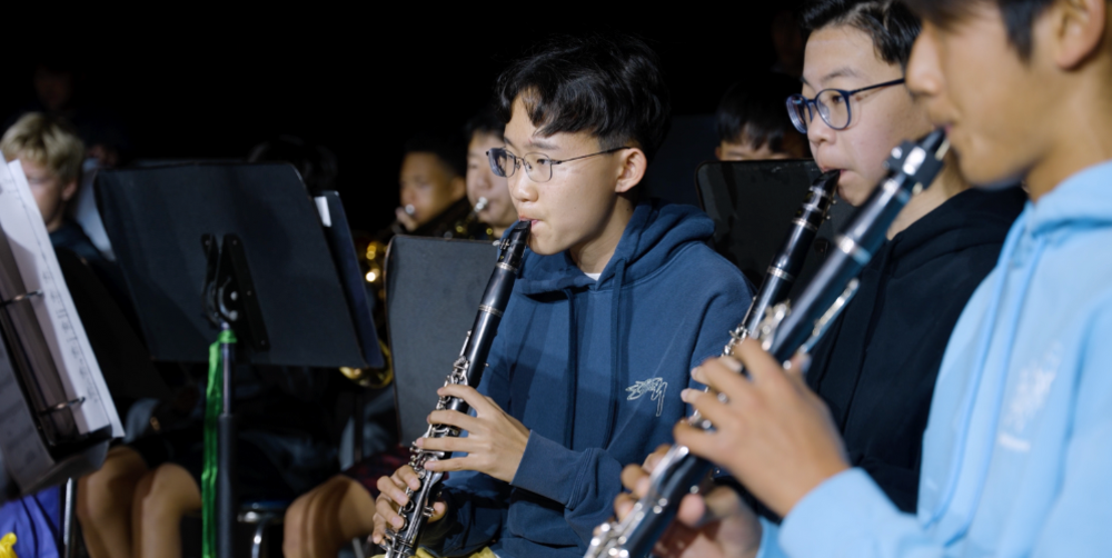 Students playing clarinets in a music performance.