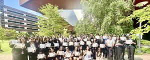 Image of students standing outside holding up their certificates of recognition