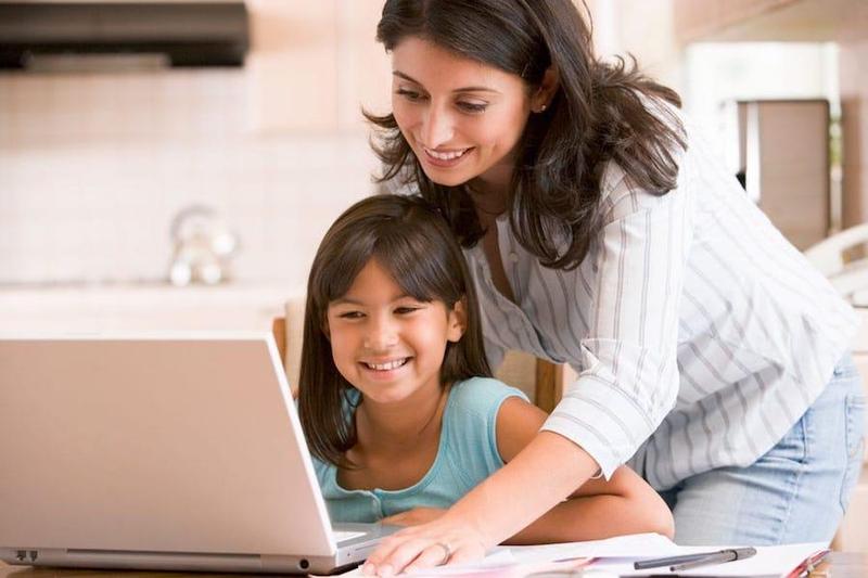 Parent helping a child on a laptop