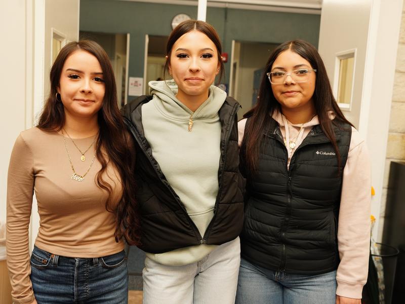 Three female students smiling for a photo.
