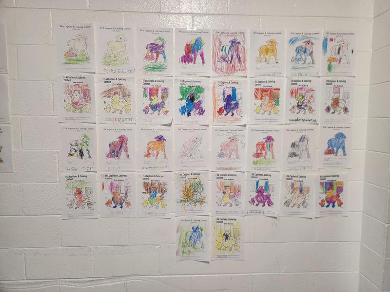 Coloring contest entries hanging on a wall.
