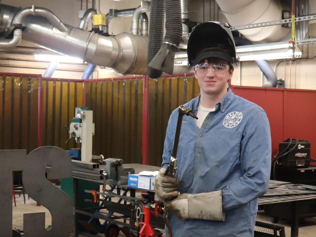 A student holding up a tool at the Upper Bucks County Technical School.