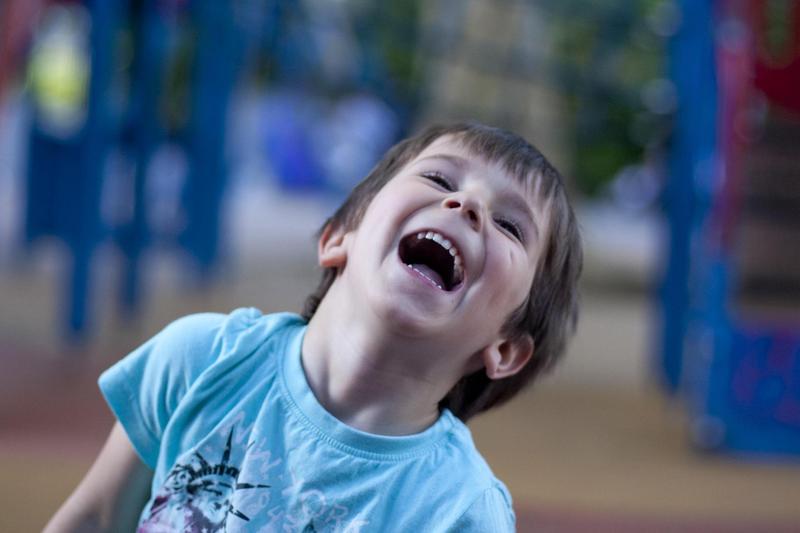 A young child laughs on a playground