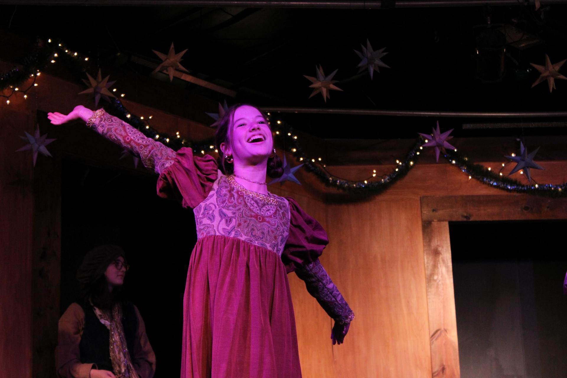 student on stage acting with arms open