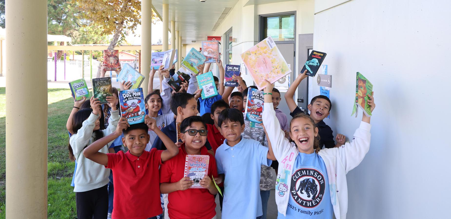 Student excitedly showing off their new books they checked out from the library.
