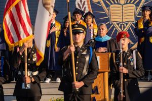 Graduates Salute the flag during the national anthem