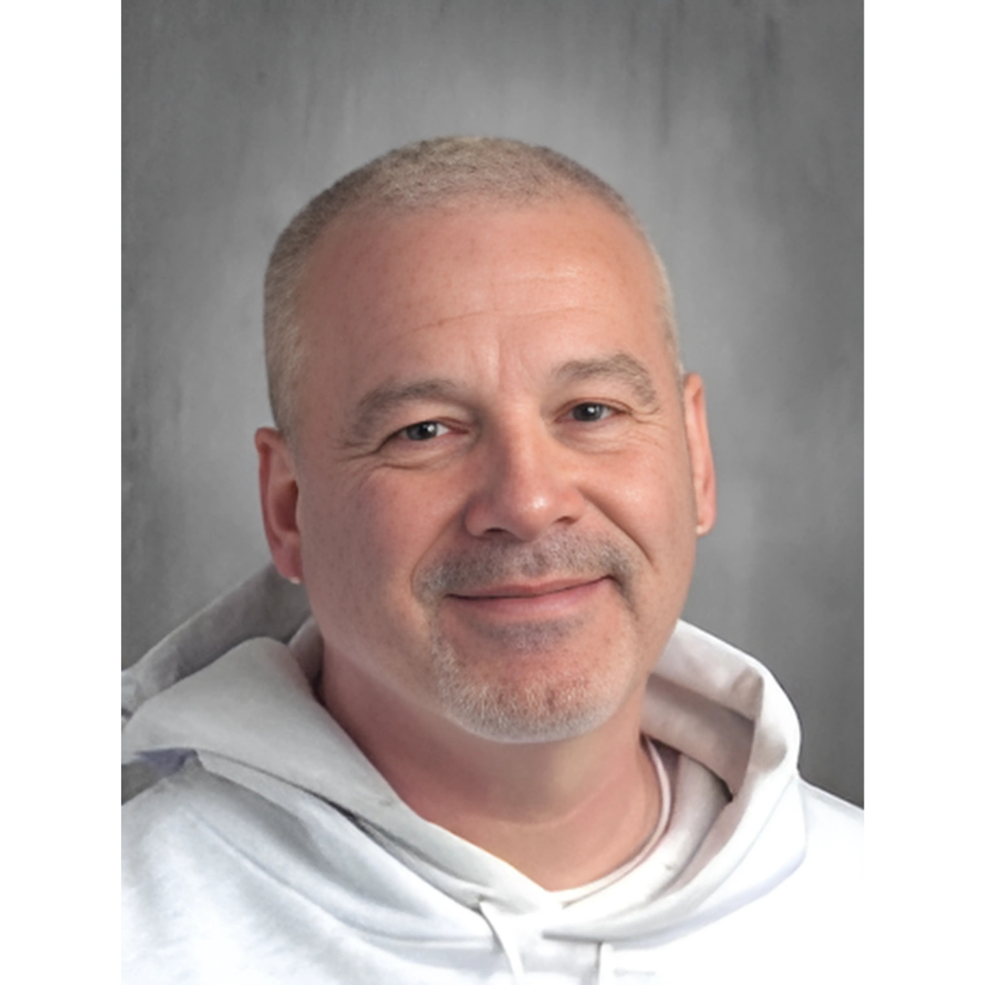 a person in a white hoodie smiling for the camera