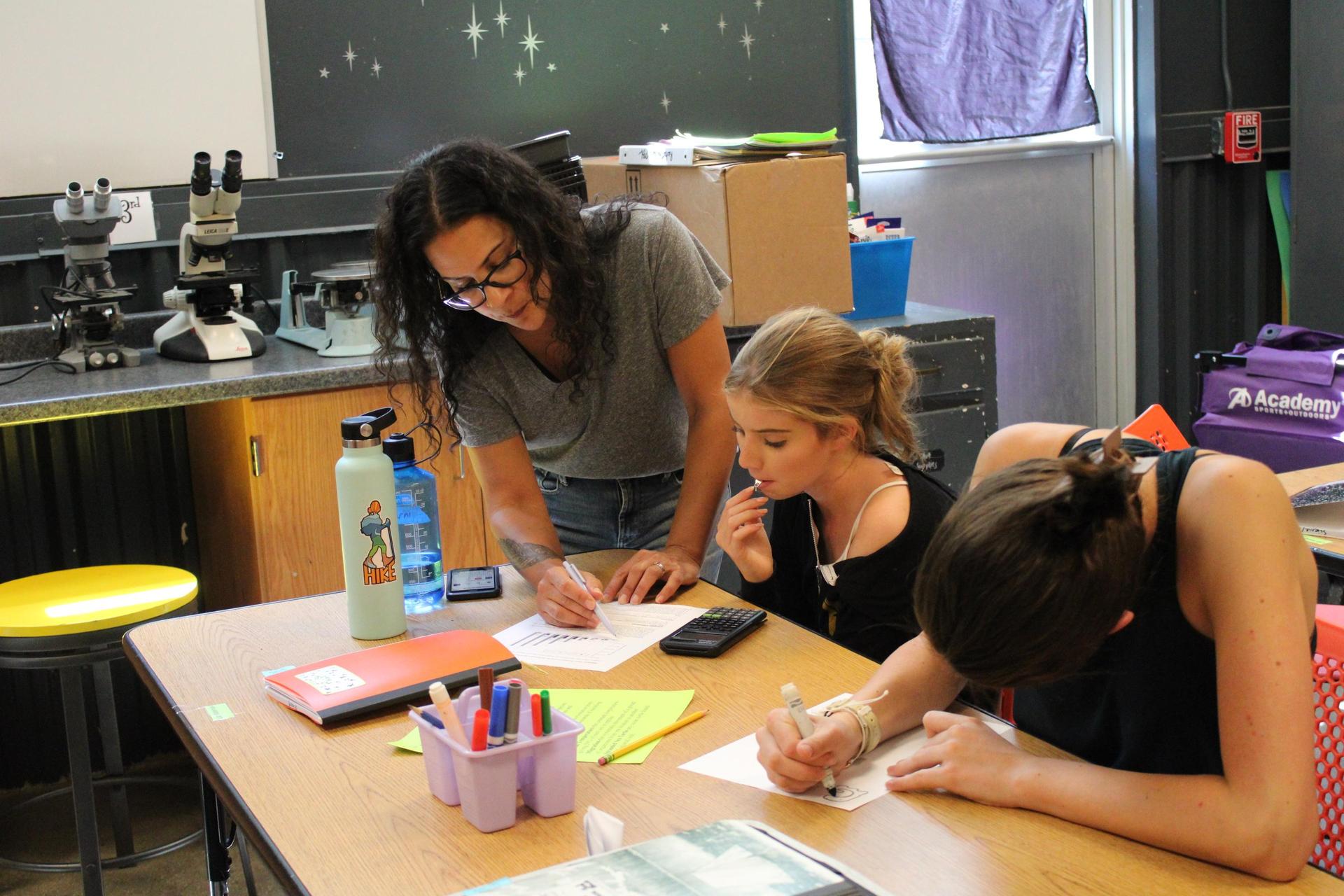 A teacher works one on one with a student in a Science class.