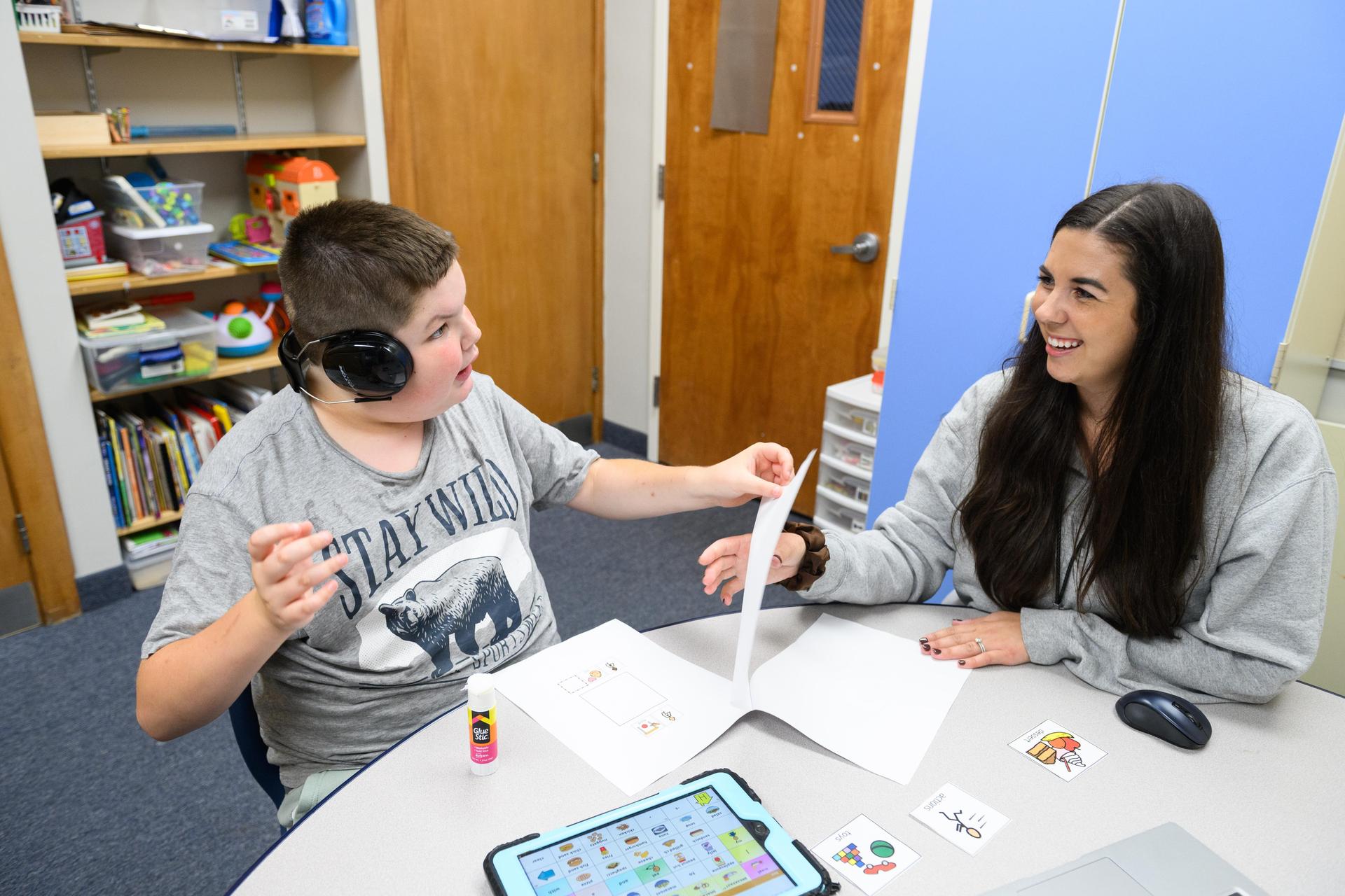 Student on left and teacher on right interacting.