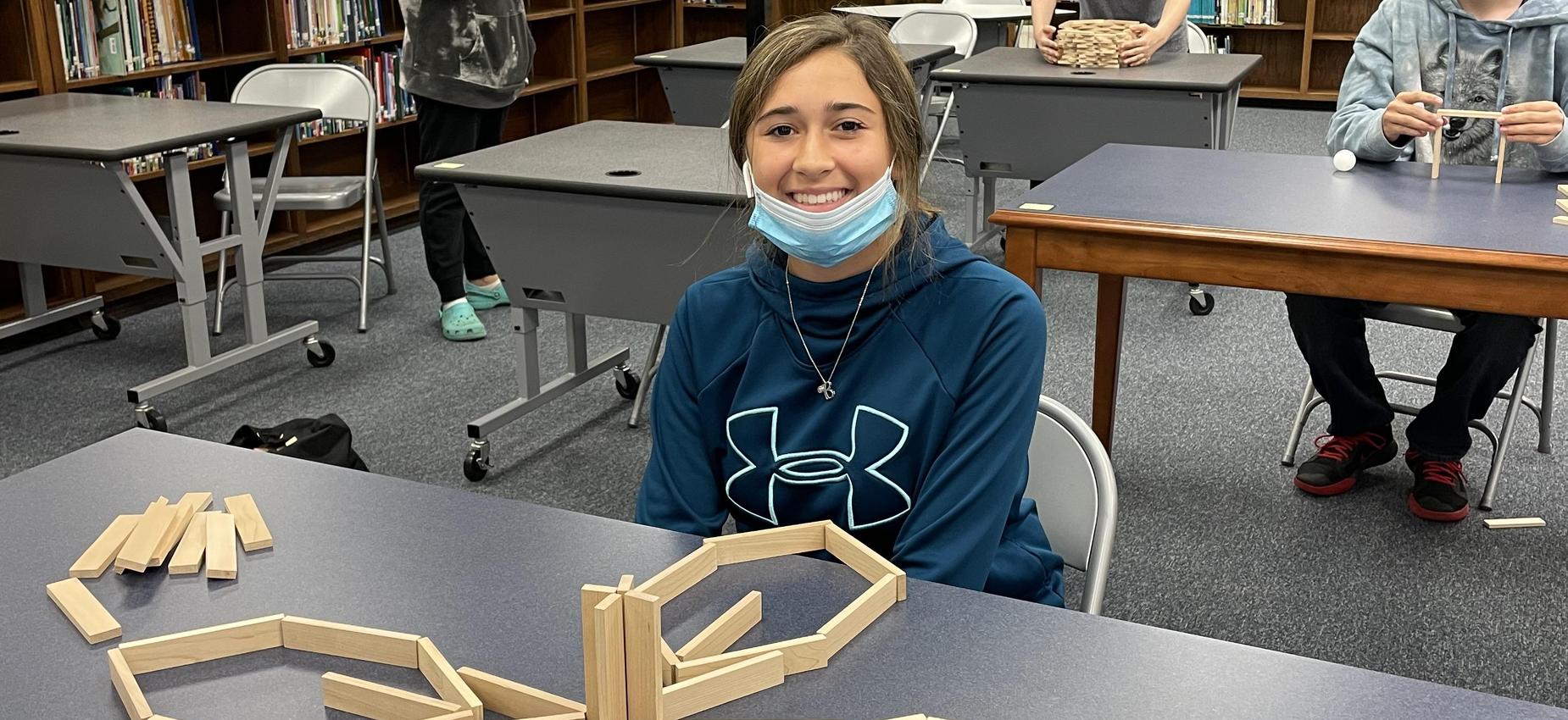 A student works with blocks in a library.