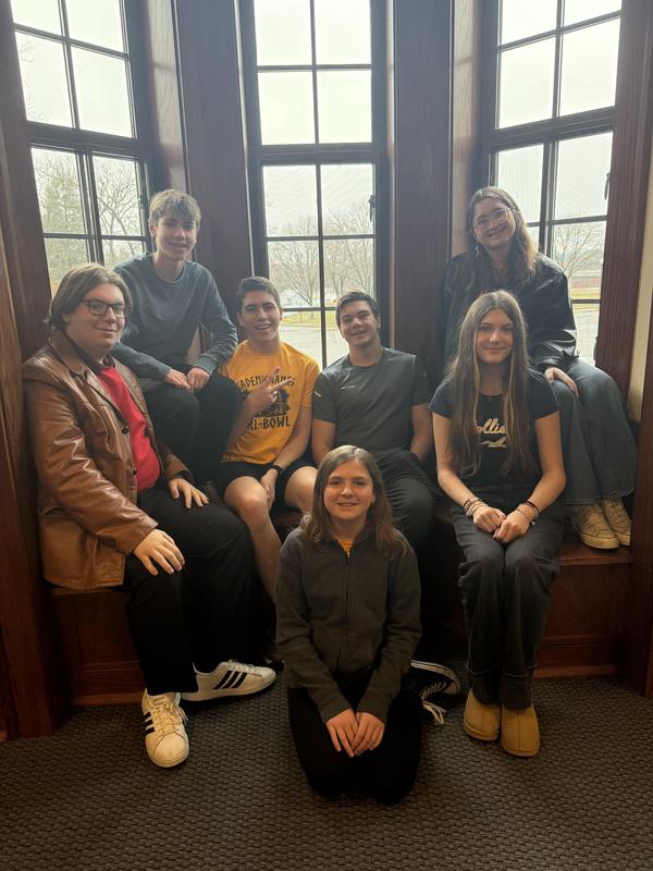 students sit smiling in library window