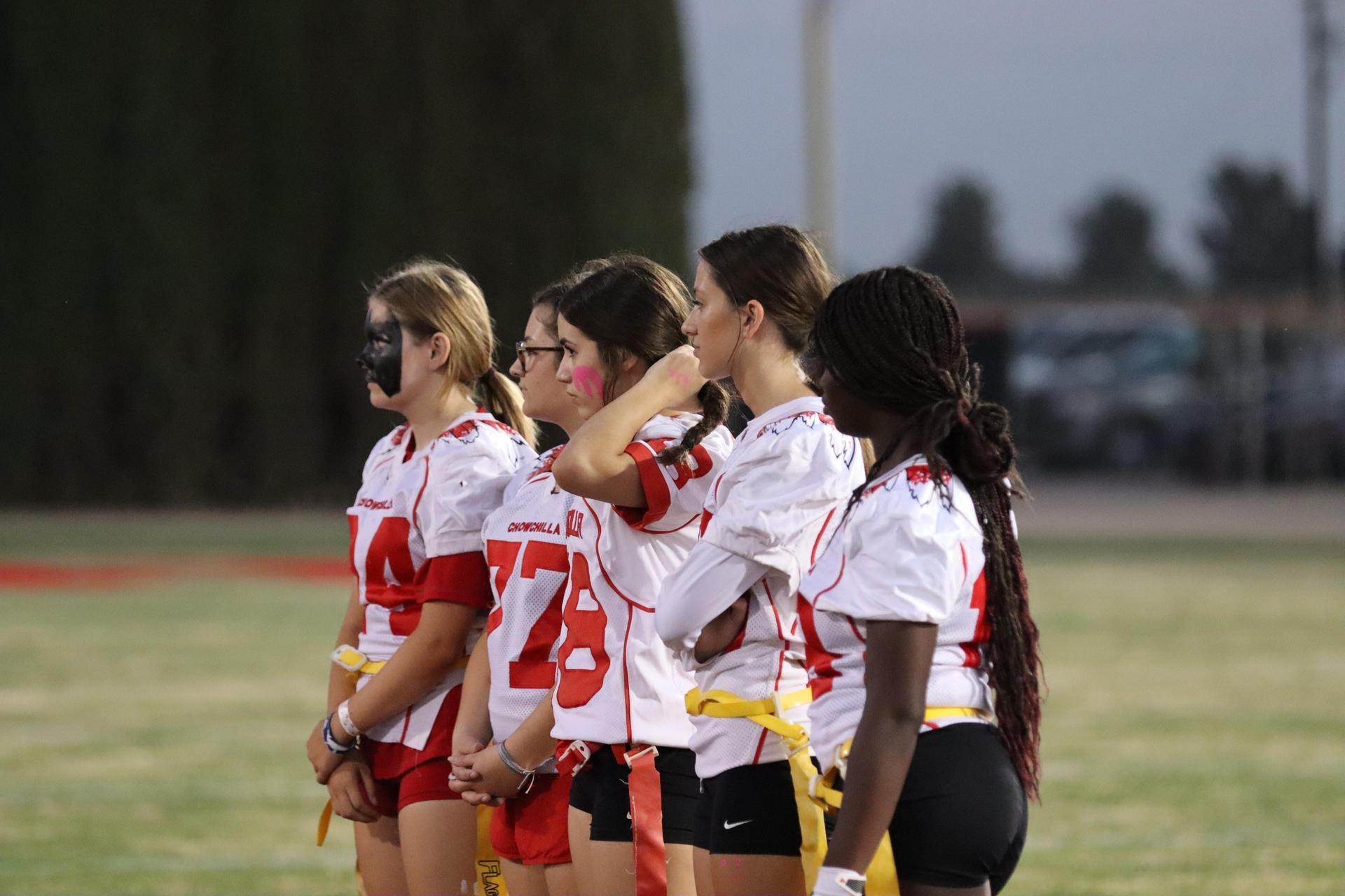 players, cheerleaders, and officials preparing for the powderpuff football game