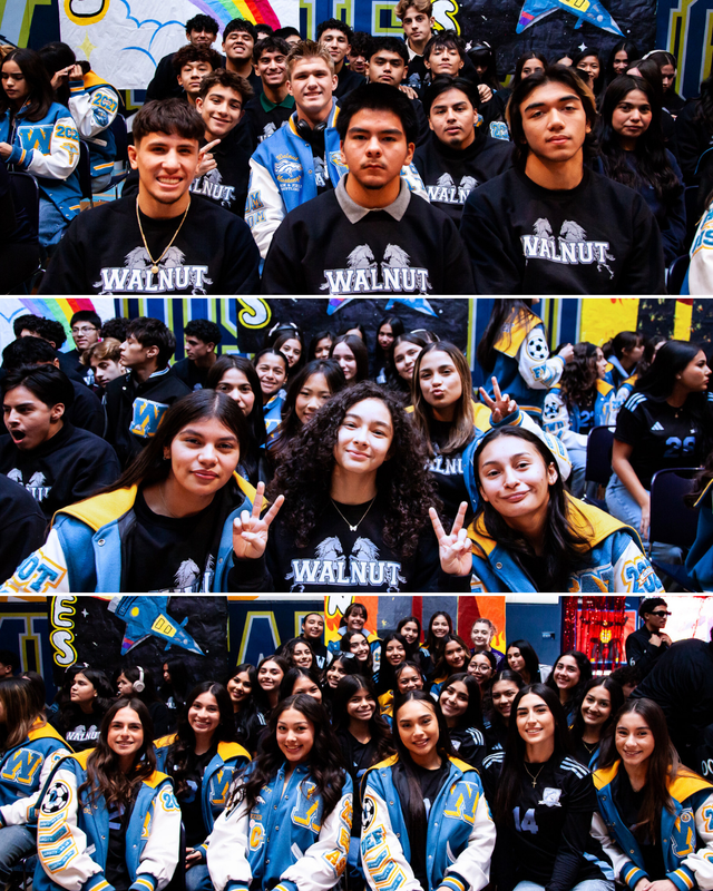 Large group of students in jackets posing happily for the camera at school assembly.