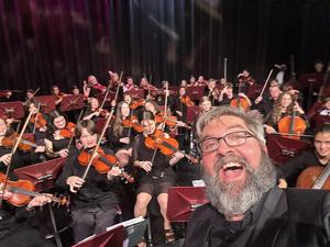 Mr. Cohen in front of students performing