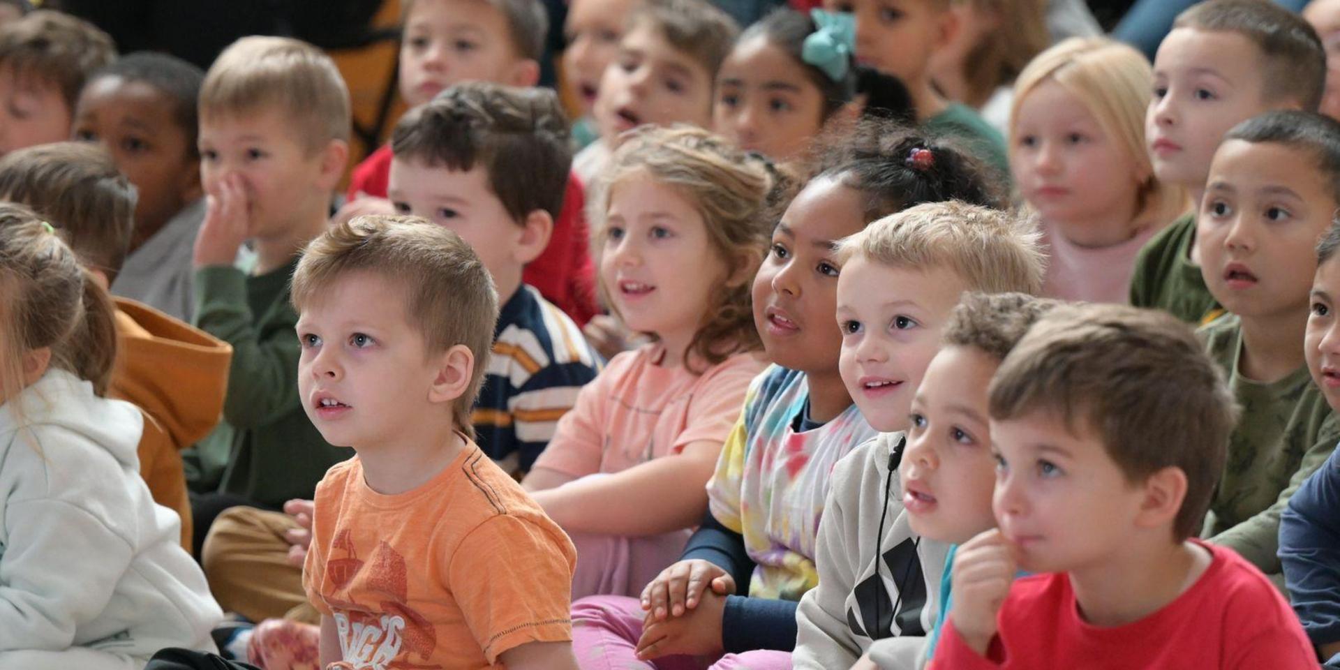 Group of children engaged and watching an event or performance.