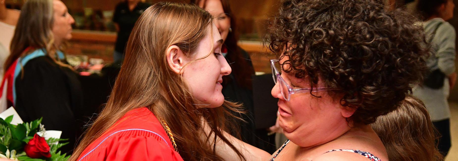 Mom hugging daughter that graduated.