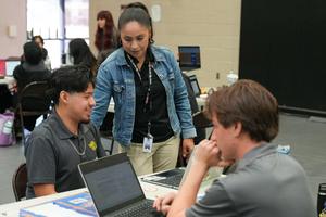 counselor helping two boys with laptops during Senior Apply Day