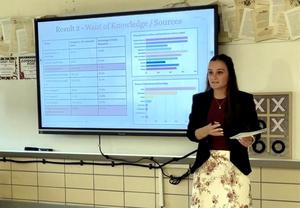 Student presenting data on knowledge sources in a classroom setting.