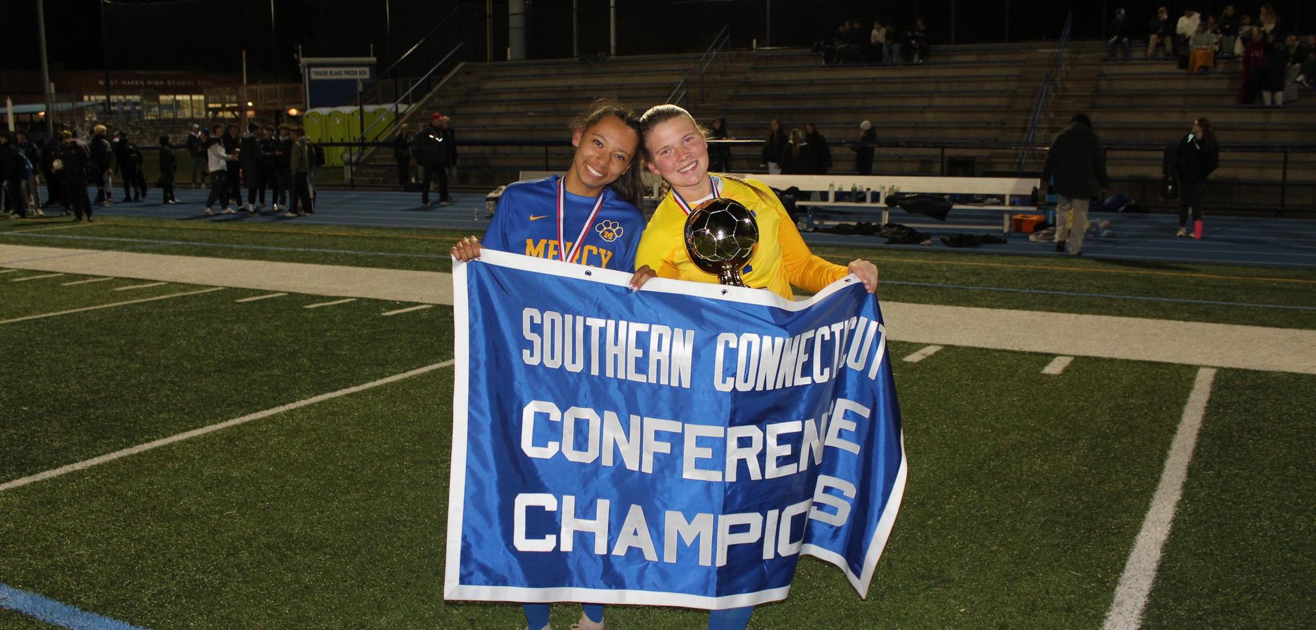 Two athletes celebrating a championship win with a banner.