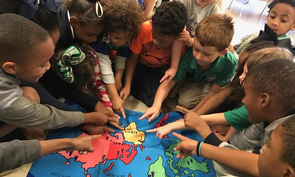 Mrs. Thomas' first grade class finding Africa on the map after reading an African folk tale,