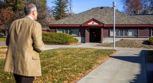 A man walks towards a building on a path