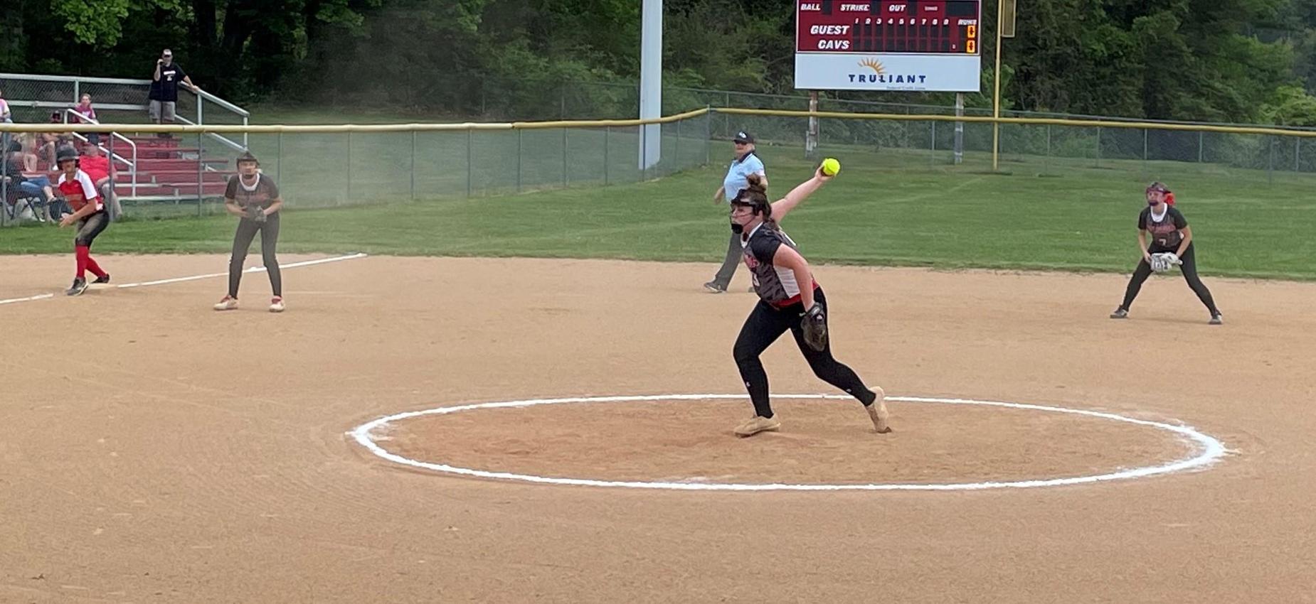 A softball player pitches a ball.