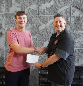 TKHS Senior Thomas Poll receives a certificate from HS Principal Tony Petersen.