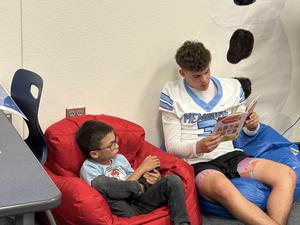 memorial high school student reading to legacy elementary student